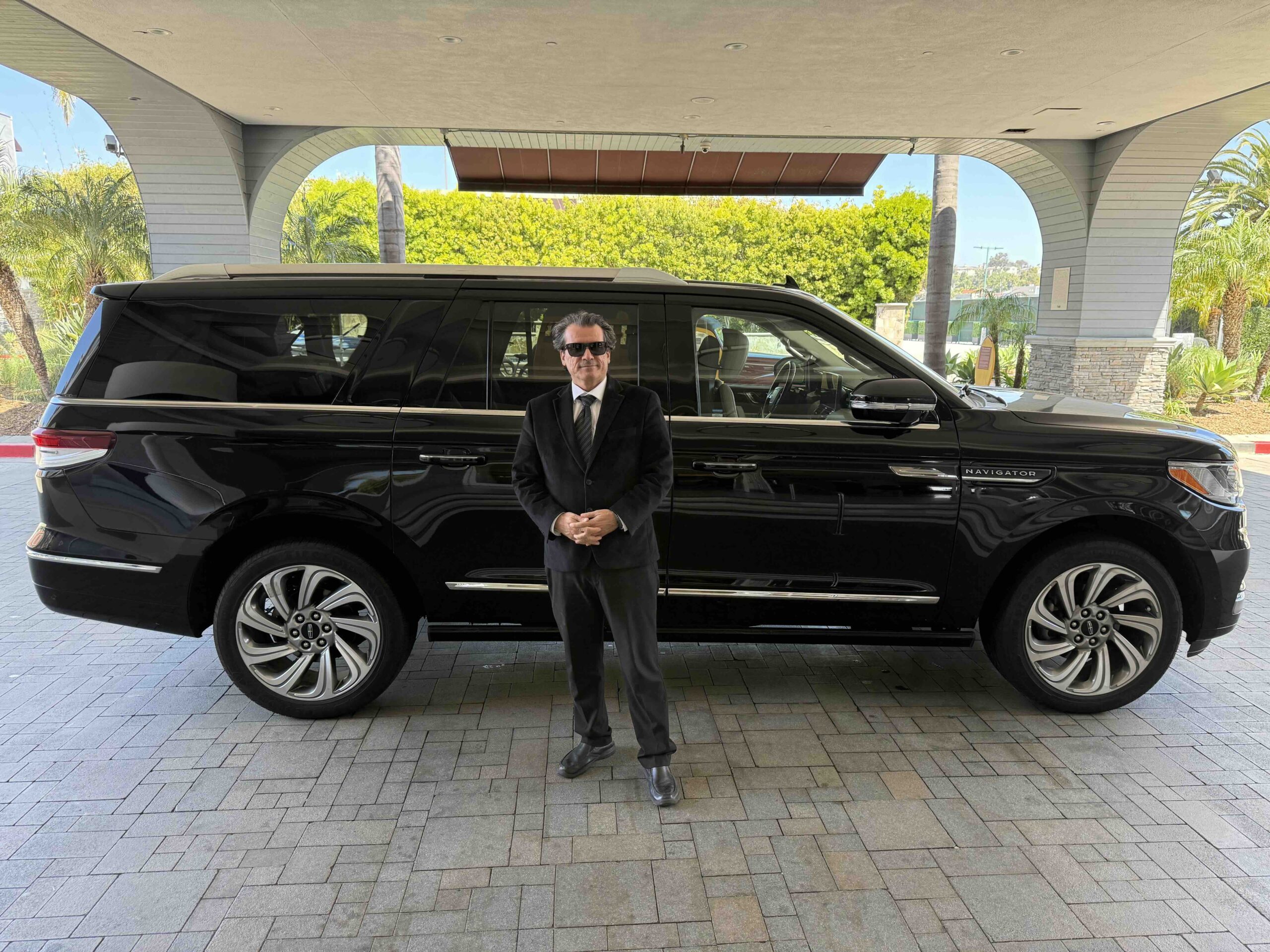 Emelx professional chauffeur with luxury SUV providing LAX car service